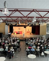 Das Bild zeigt von hinten die Besucher, wie sie eine Szene des Stücks folgen.